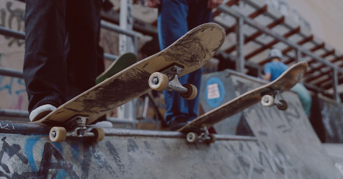 Teenagers skateboarding on a graffiti-covered ramp, showcasing urban culture.